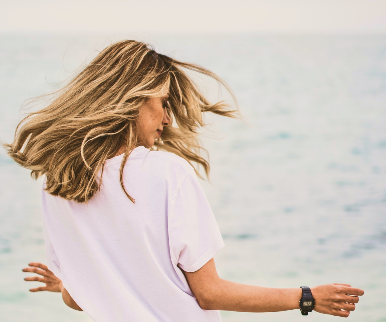 Woman with voluminous blonde hair by the sea